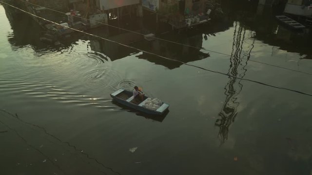 A young man delivers fresh bottled water for drinking, washing and cooking to the floating homes of Artex Complex, Philippines 