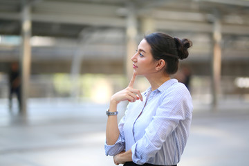 Obraz premium Portrait of smiling young beautiful business woman standing at outside.