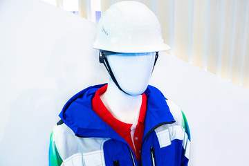 Clothes for builders. The dummy is wearing a construction helmet and jacket. Work clothes with reflective elements. Sale of working clothes.