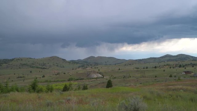 Country side pan on a cloudy evening with a thunderstorm in background.