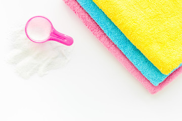 Laundry concept. Clean linen near washing powder on white background top view copy space