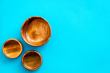 Making wooden dishes. Empty bowls on blue background top view copy space