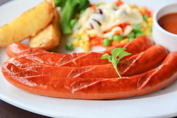 Grilled homemade sausage served with sauce and salad