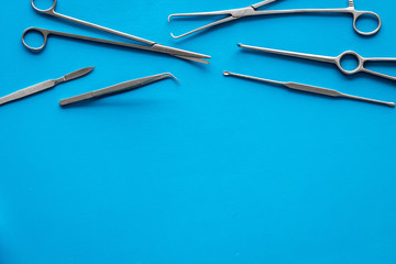 Plastic surgery. Instruments for beauty operations on blue background top view frame copy space