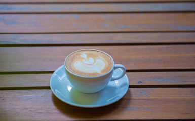 cup of tea with teapot and flowers on wooden table