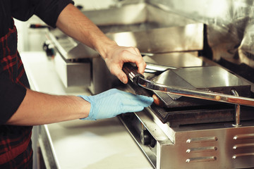 Cook prepares a hamburger.