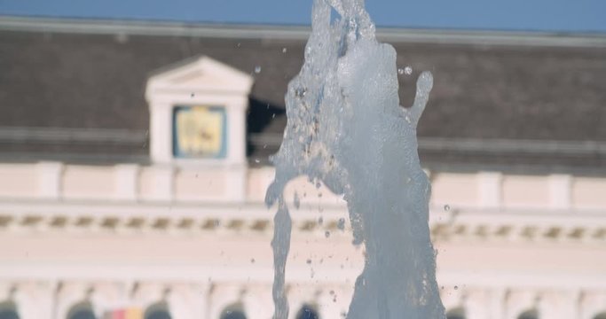 Close up slow motion shot, fountain with refocus to old castle, mansion, royal palace in Europe (Austria), 4K.