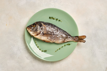 baked Dorado fish on a green plate