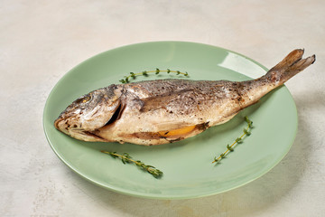 baked Dorado fish on a green plate