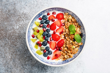 Breakfast smoothie bowl with fruits and granola. Superfood bowl isolated on concrete background. Clean eating, dieting, weight loss concept