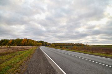 Track from the car window and white clouds on blue sky. Natural landscape