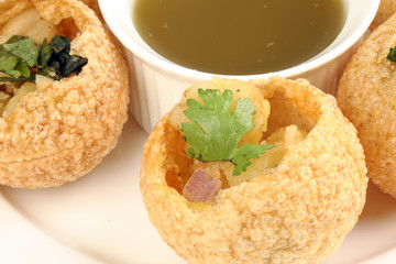 Tadeonal subcontinental street snack food chickpeas potato pani puri fuska with tamarind sauce