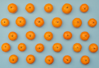 Blue background with orange tangerines. Flat lay style.