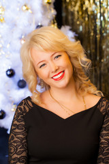 Attractive young blonde woman on holiday background. New Year and Christmas concept.