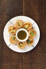 Tadeonal subcontinental street snack food chickpeas potato pani puri fuska with tamarind sauce