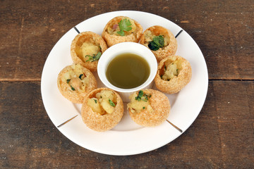 Tadeonal subcontinental street snack food chickpeas potato pani puri fuska with tamarind sauce © oqba