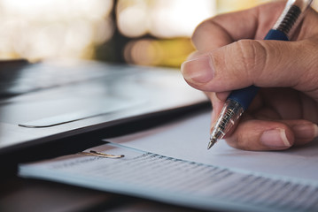 Businesswoman holding pen writing on paper document working,Close up hand write paperwork