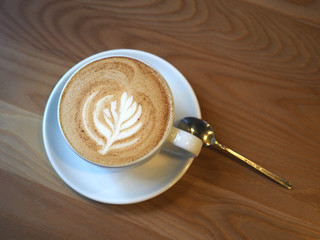 Cup of coffee latte in a mug on the table. Morning in a city cafe