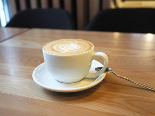 Cup of latte coffee in a mug on a table in a cafe. Morning in a city cafe