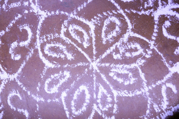 Indian traditional kolam (known in tamil language) or rangoli is drawn using white colored rice,...