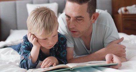 dad reading a storybook with his son, childhood bonding close relationship love tender moment - Powered by Adobe