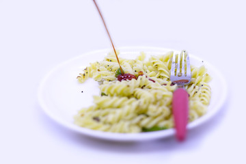 Pasta in tomato sauce with fork on a white background