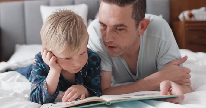 dad reading a storybook with his son, childhood bonding close relationship love tender moment
