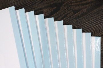 Stack of books with a blue hard cover on wooden background. Composition from books
