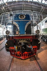 blue locomotive on a train station platform