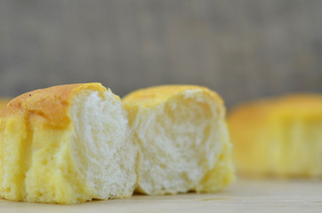 Delicious soft bread open in half on a wooden background