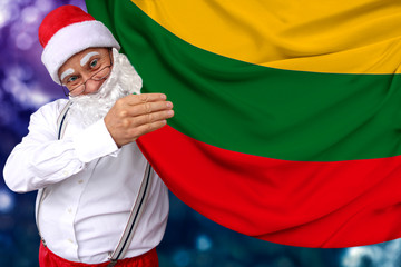 Santa Claus with a beard holds a beautiful colored national flag of the state of Lithuania on fabric, concept of tourism, New Year and Christmas, economic and political prospects