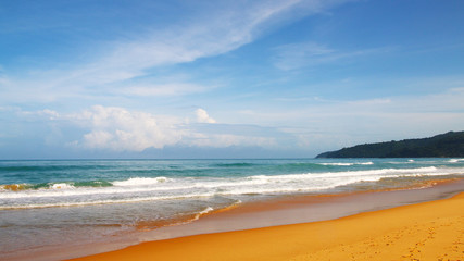 Waves, surf, and the blue sky over the sea, Karon sandy beach on a sunny day, Thailand