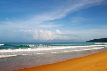 Waves, surf, and the blue sky over the sea, Karon sandy beach on a sunny day, Thailand