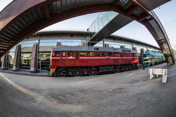 red locomotive on the platform of the railway station