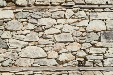 Old stone wall with two wooden beams closeup