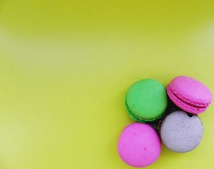 Obraz na płótnie Canvas Bright sweet macaroon cookies on a yellow background with space for text 