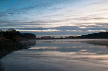 sunny morning on forest lake against forest background