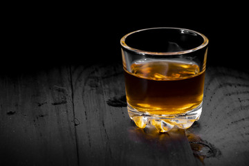 one glass of cognac on a black tree