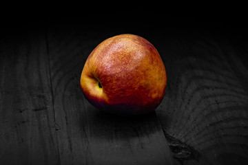 one nectarine green close up black background