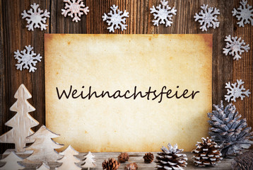 Old Paper With German Text Weihnachtsfeier Means Christmas Party. Christmas Decoration Like Tree, Fir Cone And Snowflakes. Brown Wooden Background