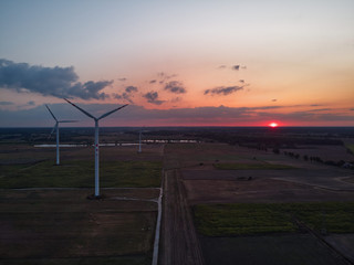 Turbiny wiatrowe na tle zachodzącego słońca © Filip