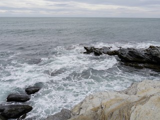 Fototapeta premium Top shot of waves breaking on the rocky shores