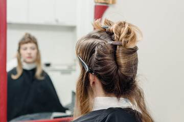 Fototapeta premium Closeup of professional stylist using brush to apply dye on clients hair