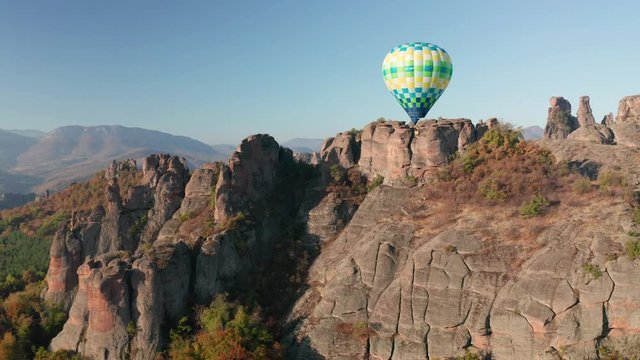 Amazing panoramic video with hot air balloon flying over picturesque rock formation lit by the morning autumn sun, Belogradchik rocks, Bulgaria 
