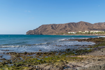 The beautiful Las Playitas beach in Fuerteventura, Canary Islands, Spain, with the moon in the blue sky