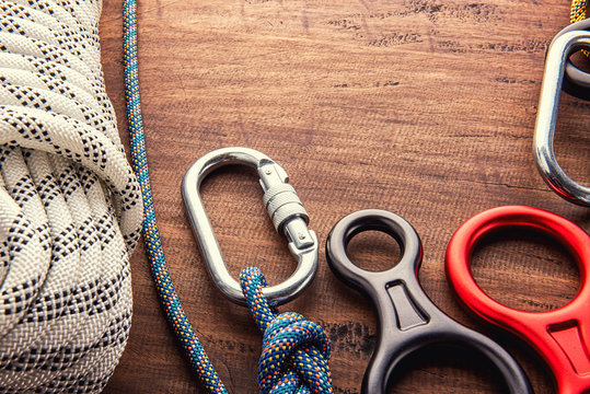 Climbing Equipment Outdoor For A Mountain Trip Or Rescue.With Rope Carabiners Ascender Belay/rappel Device, Over Concrete Background With Copy Space On Wooden Background, Top View. Travel Concept