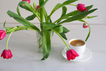 cup of coffee with flowers and leaves on wooden background