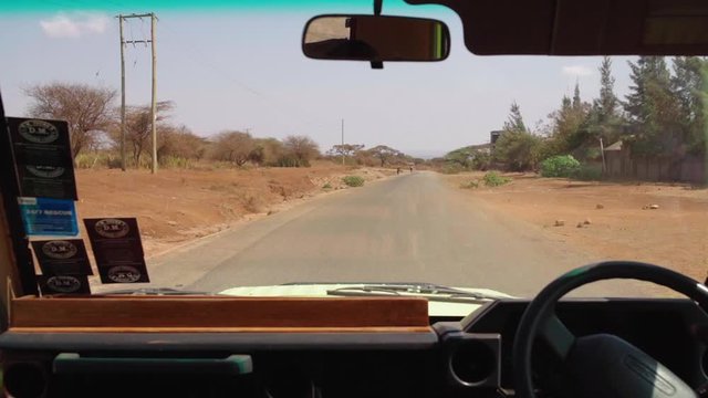 Driving with tour guide on Chinese funded and built road / street in Kenya. Ride went from Tsavo East to Tsavo West National Park. Chinese infrastructure in Africa.