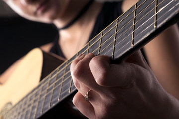 Beautiful teenager girl playing an acoustic guitar