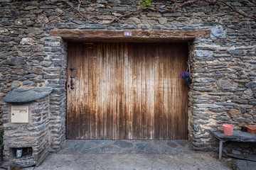 Fototapeta na wymiar Rustic wooden door of a schist stone building